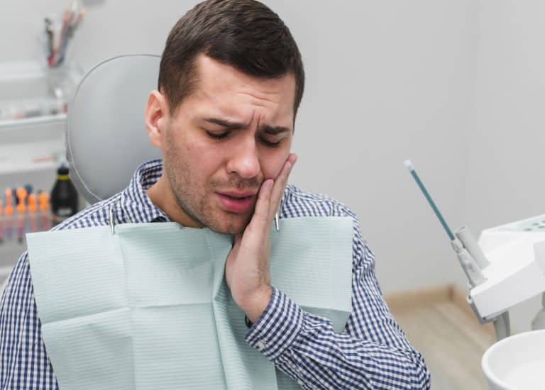 Un bărbat pe scaunul unui stomatolog la Stomatolog Rahova suferă de dureri de dinți.