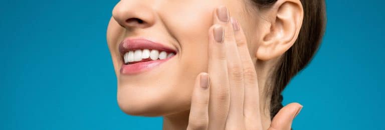 O femeie cu mâinile pe față la dentist din București.