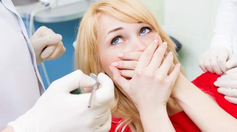 O femeie este examinată de un stomatolog la o clinică de stomatologie din Rahova.